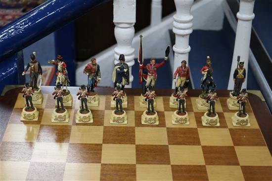 A Waterloo chess set by Charles Stadden, No. 27/250, in military style brass-bound mahogany games table on folding stand